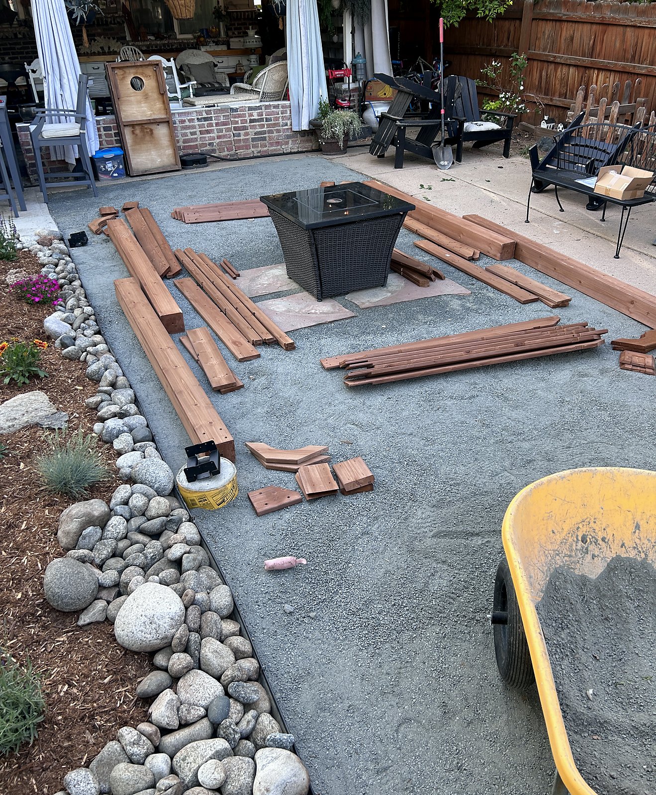 Compacted base with cedar pergola members cut and staged, river rock border in place