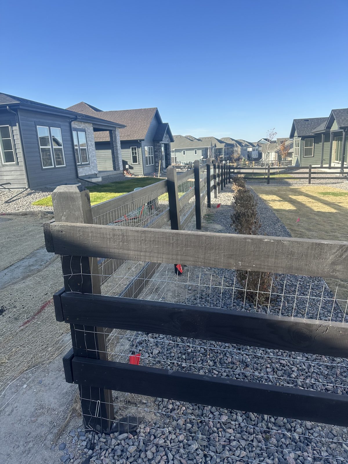 Split rail fence with welded wire backing at a new construction subdivision